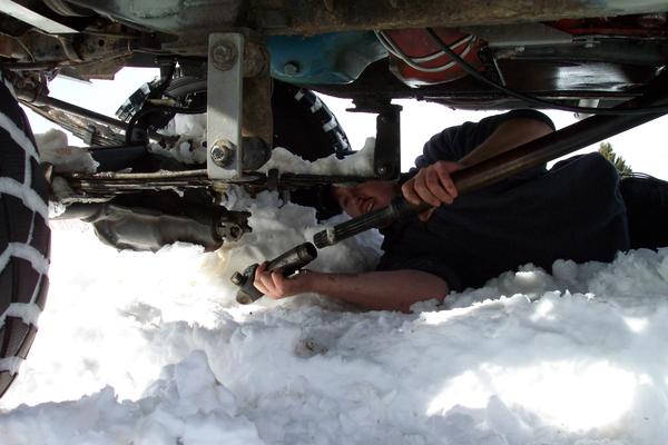 Loretta's front driveshaft came apart when Mike tried ot winch hte Jeep backwards - Bozeman Mountaineer Rob Currier puts it back