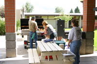 Dennis and Allison LaTulip work the smoker while Michelle Mandera watches